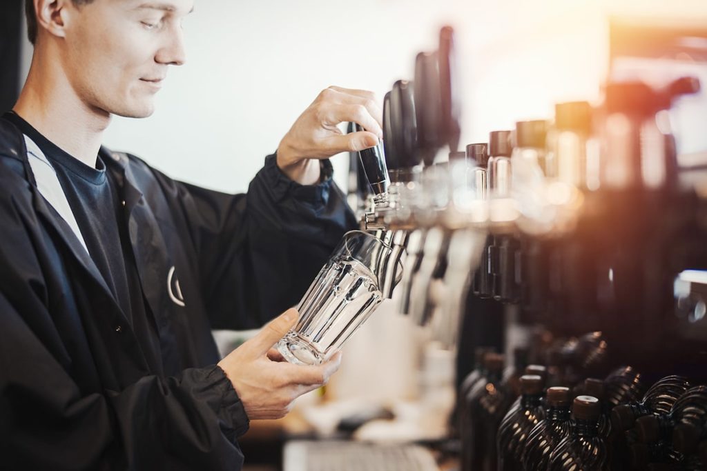 Man pouring beer in bar